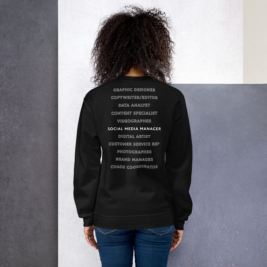 Back of a black sweatshirt that lists different roles that a social media manager plays. The extra roles are just outlined while Social Media Manger is bold and white.